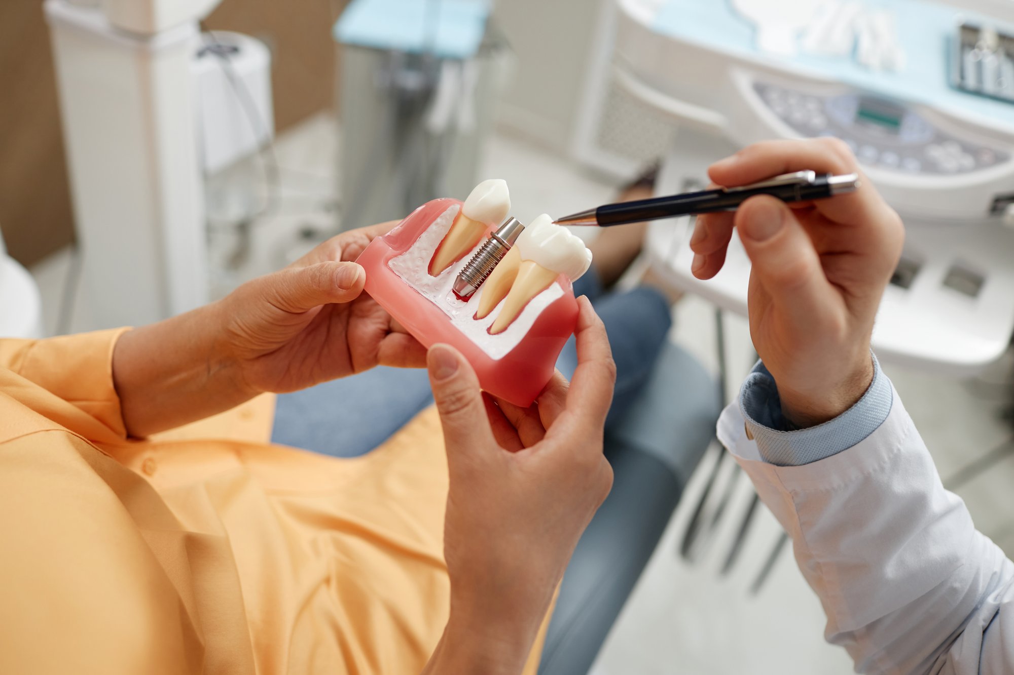 A dental implant model showing the titanium post and crown